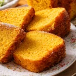 Fetta di Torta Camilla alle Carote con decorazioni di carote e noci.